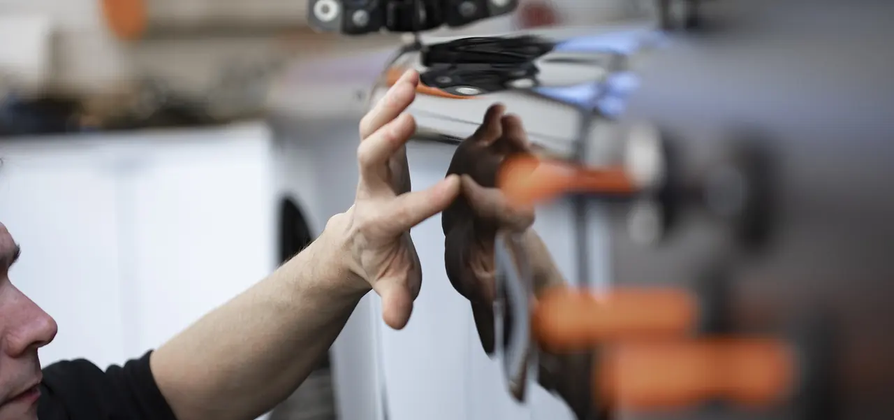 A JLC bodyshop technician checking the paint finish on a freshly repaired door panel
