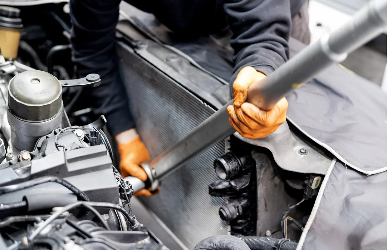 A JLC technician fitting a replacement radiator during an accident repair