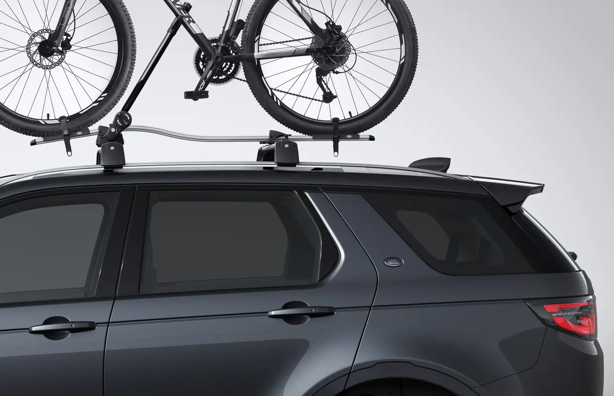 A genuine Land Rover roof-mounted bike carrier fitted to a grey Discovery Sport