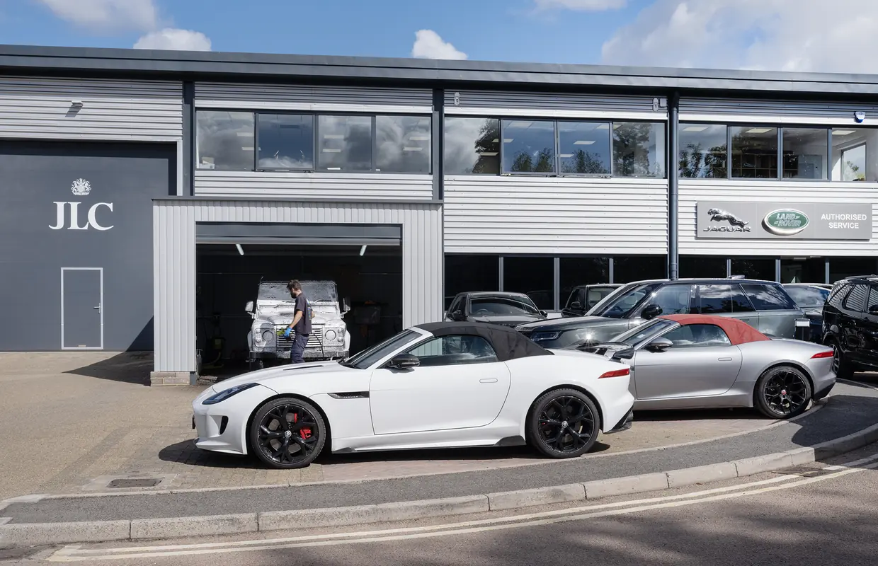 The JLC Authorised Service Centre in Sevenoaks, with two Jaguar F-TYPEs outside and a Defender in the wash bay