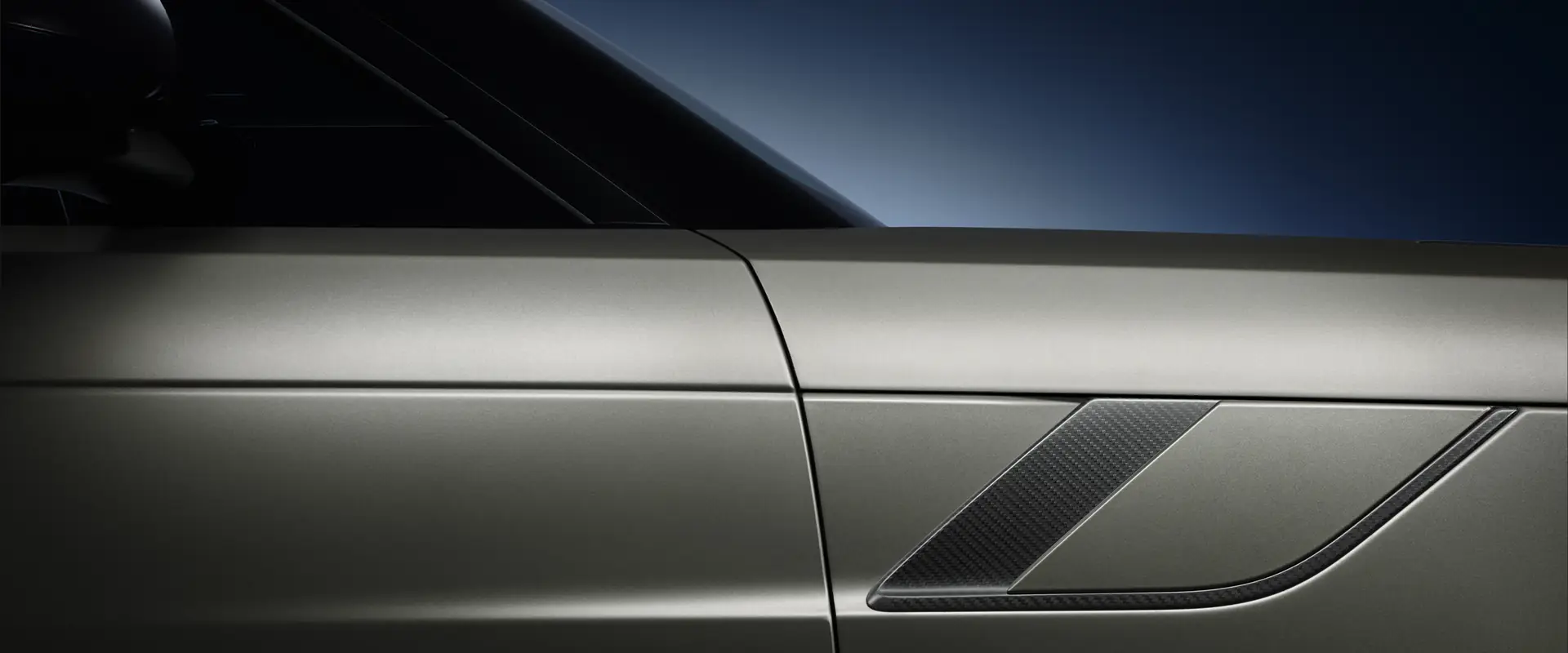 Close-up of a Range Rover Sport front wing and carbon fibre side vent in studio light
