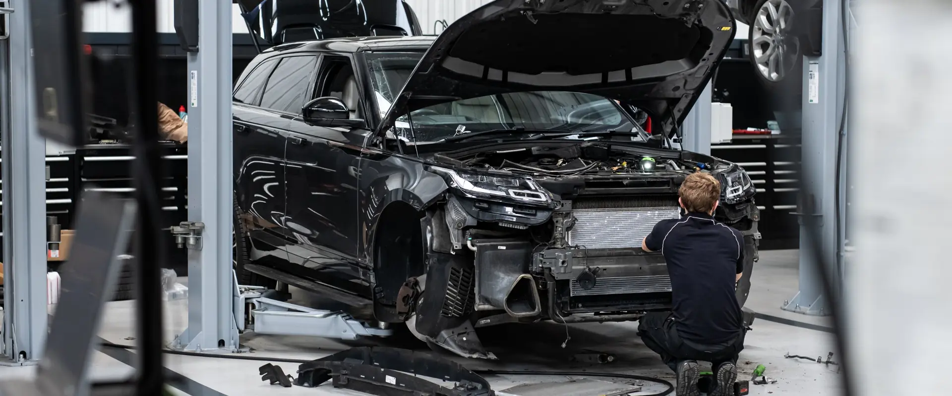 A JLC technician working on the front end of a Range Rover Velar during an accident repair in the Sevenoaks bodyshop