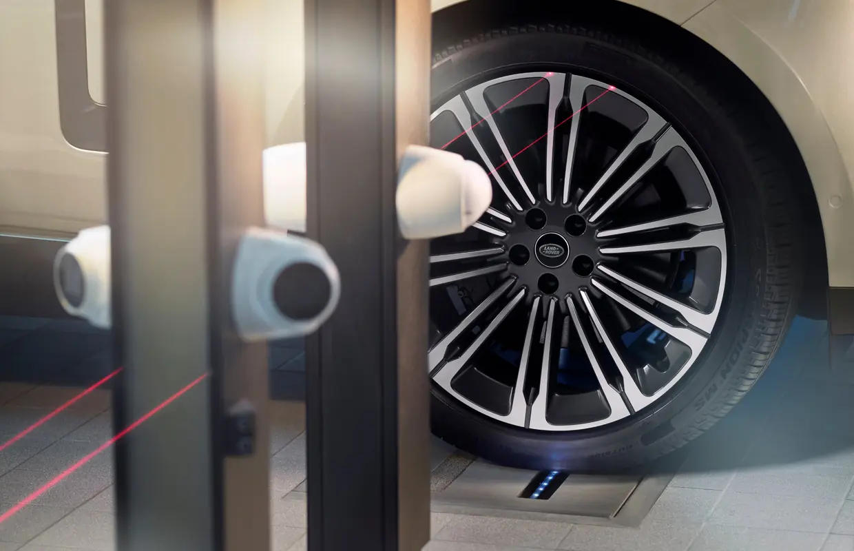 A Range Rover wheel being checked by laser alignment sensors in the workshop