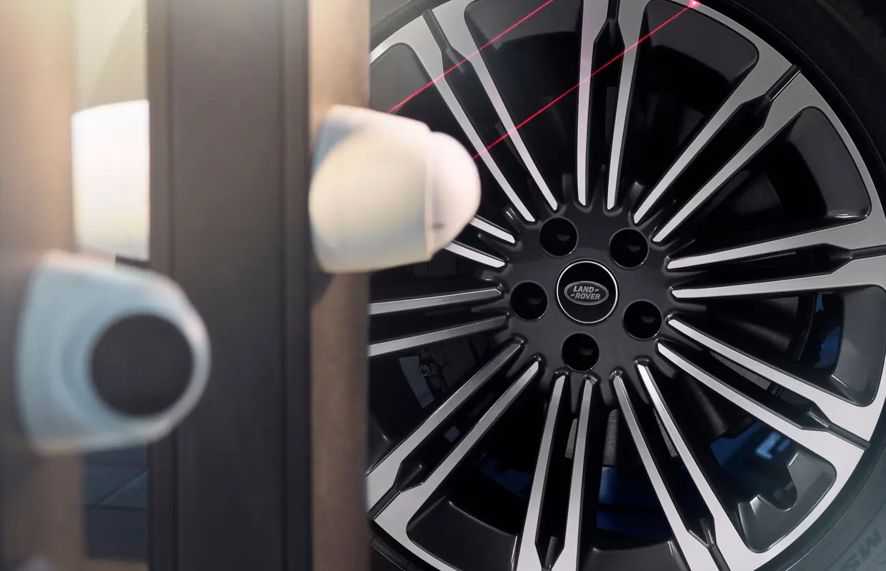 Laser alignment sensors measuring a Range Rover wheel in the workshop